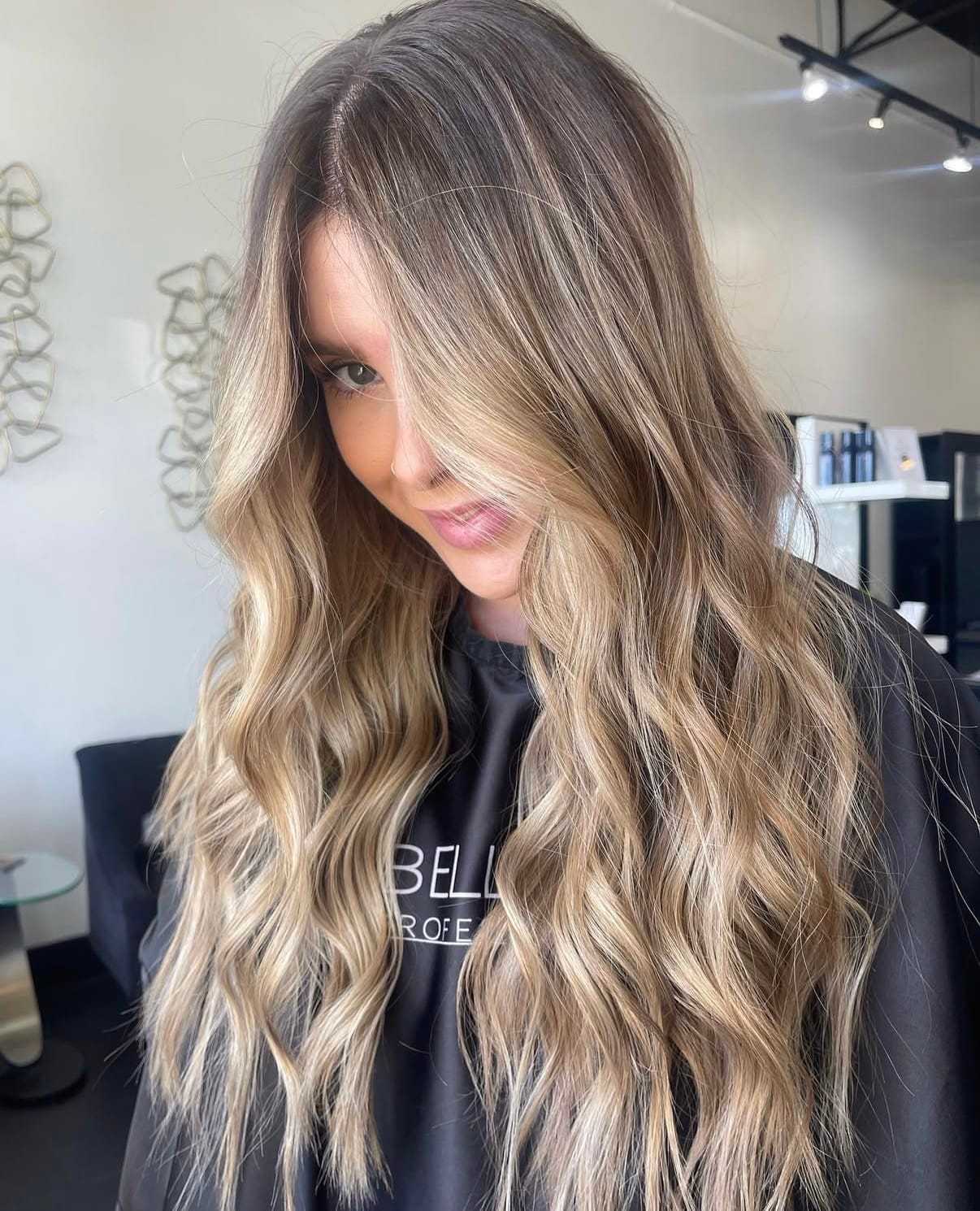 Long, wavy blonde hair styled elegantly in a modern salon setting.