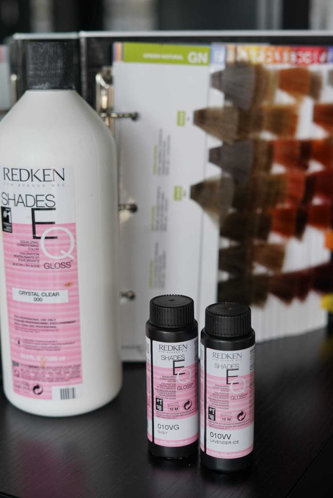 Hair color products with shade chart in the background.